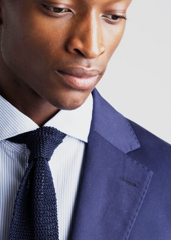 Man in a suit with a stripe knitted silk tie